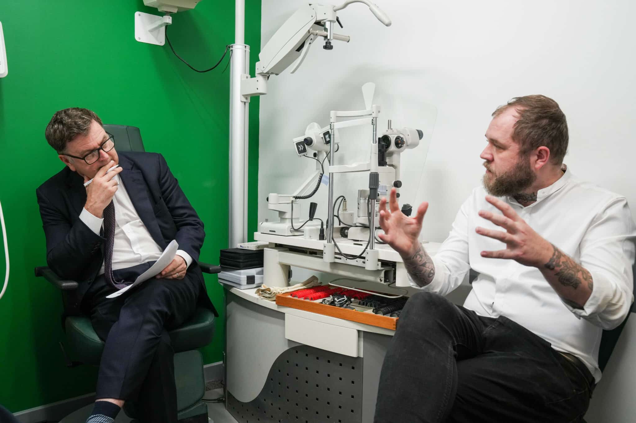 Patient having a conversation with a Optometrist in a clinical room.